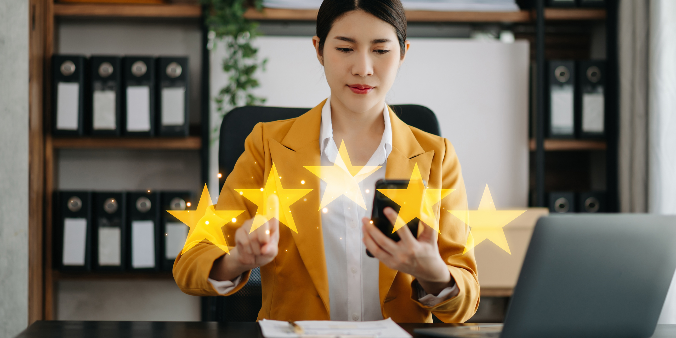 Woman giving a business a 5-star rating on her phone while sitting at her desk, a slight smile on her face, signifying satisfaction with the interaction she had with her HVAC company.